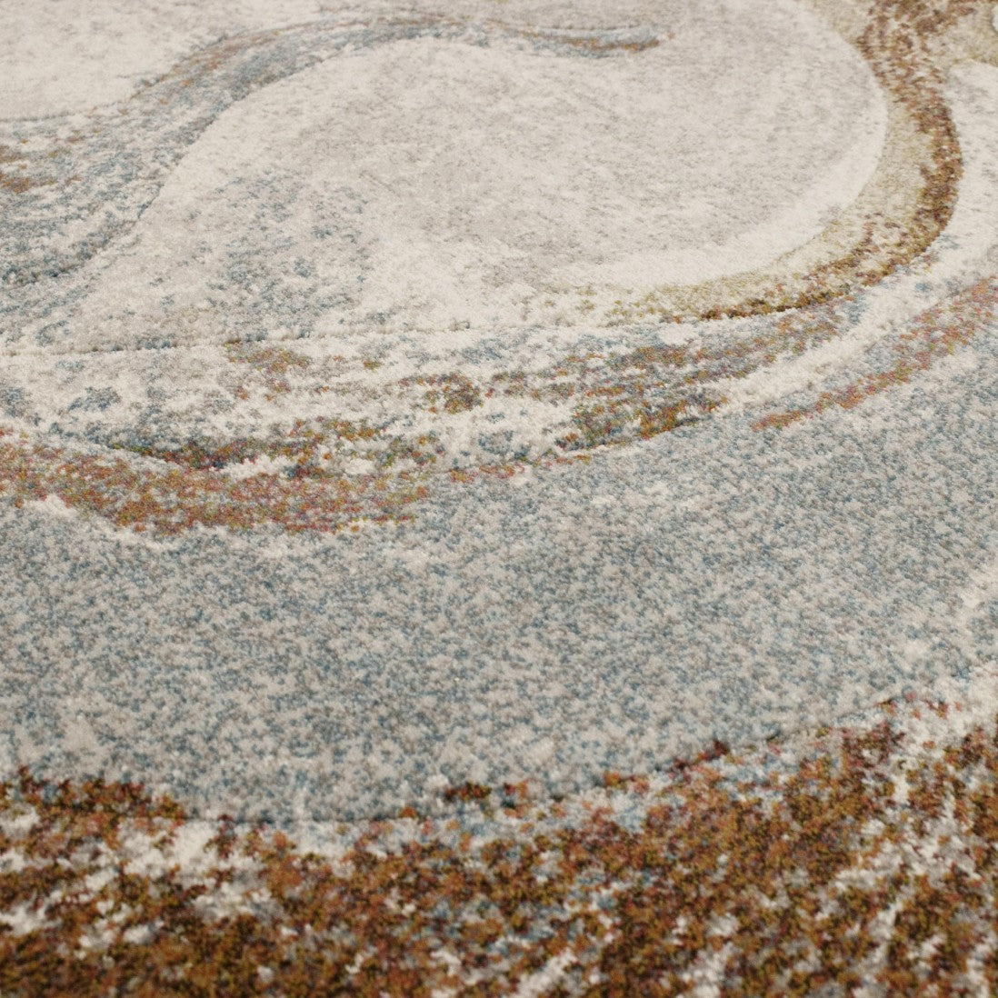 Paradise Living – Tapete Kira 63436/6250 close-up da textura densa com formas circulares em tons creme, azul-acinzentado e terracota
