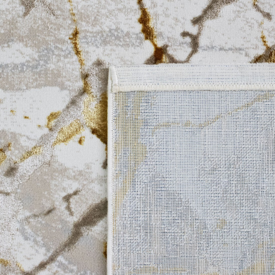Paradise Living – Tapete Marne 29/009 Amarelo, detalhe do canto com verso resistente ao desgaste e costura de rebordo branca, padrão mármore dourado e bege visível