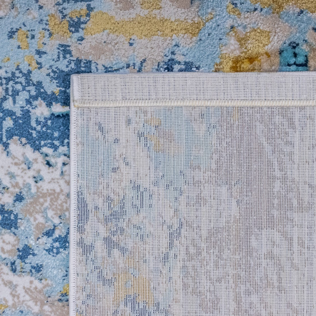 Paradise Living – Tapete Batik 38/004 Azul, detalhe do verso resistente ao desgaste com costura de rebordo e padrão visível na base