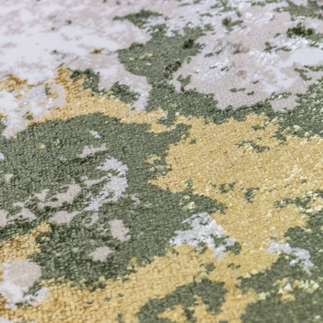 Paradise Living – Tapete Batik 38/005 Verde, close-up da textura do pelo em viscose com tons verde escuro, dourado e branco, acabamento macio e brilhante