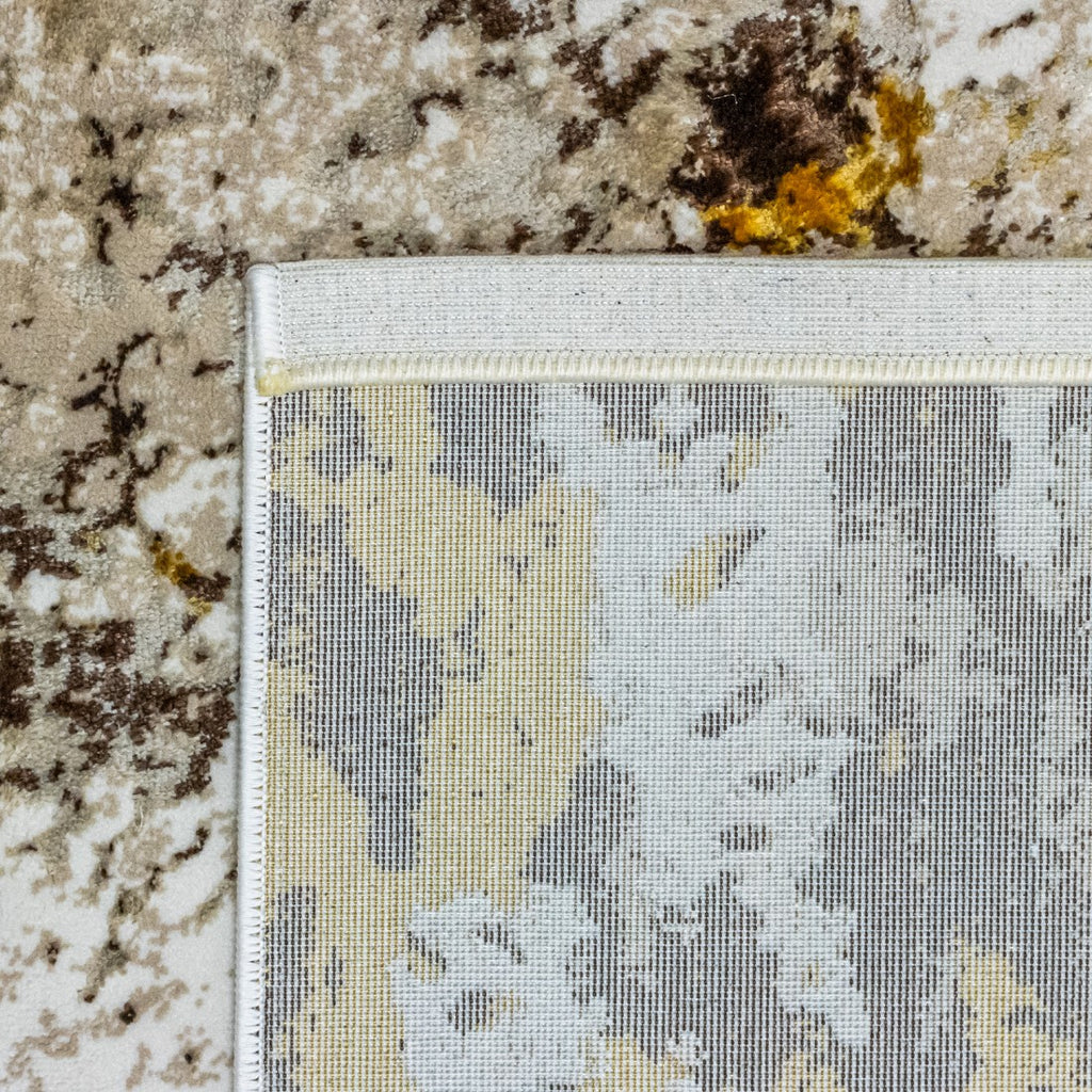 Paradise Living – Tapete Batik 38/008 Castanho, detalhe do canto com verso resistente ao desgaste e costura de rebordo, padrão castanho e dourado visível