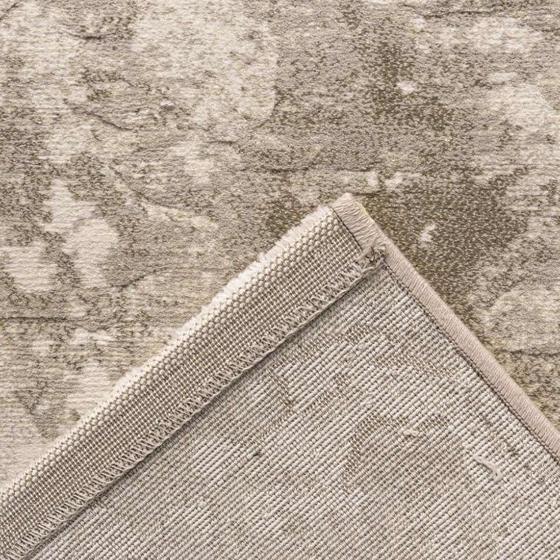 Paradise Living – Tapete Giacomo 63872/6575 detalhe do canto dobrado mostrando frente com padrão desgastado e verso em cinzento bege
