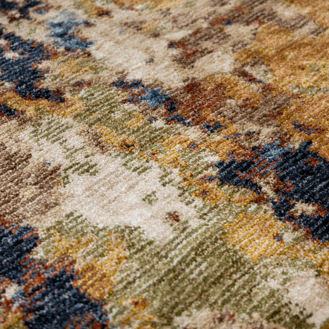 Paradise Living – Tapete Odense 7761/004 close-up da textura com médio brilho e padrão orgânico em tons dourado, verde, azul e terracota