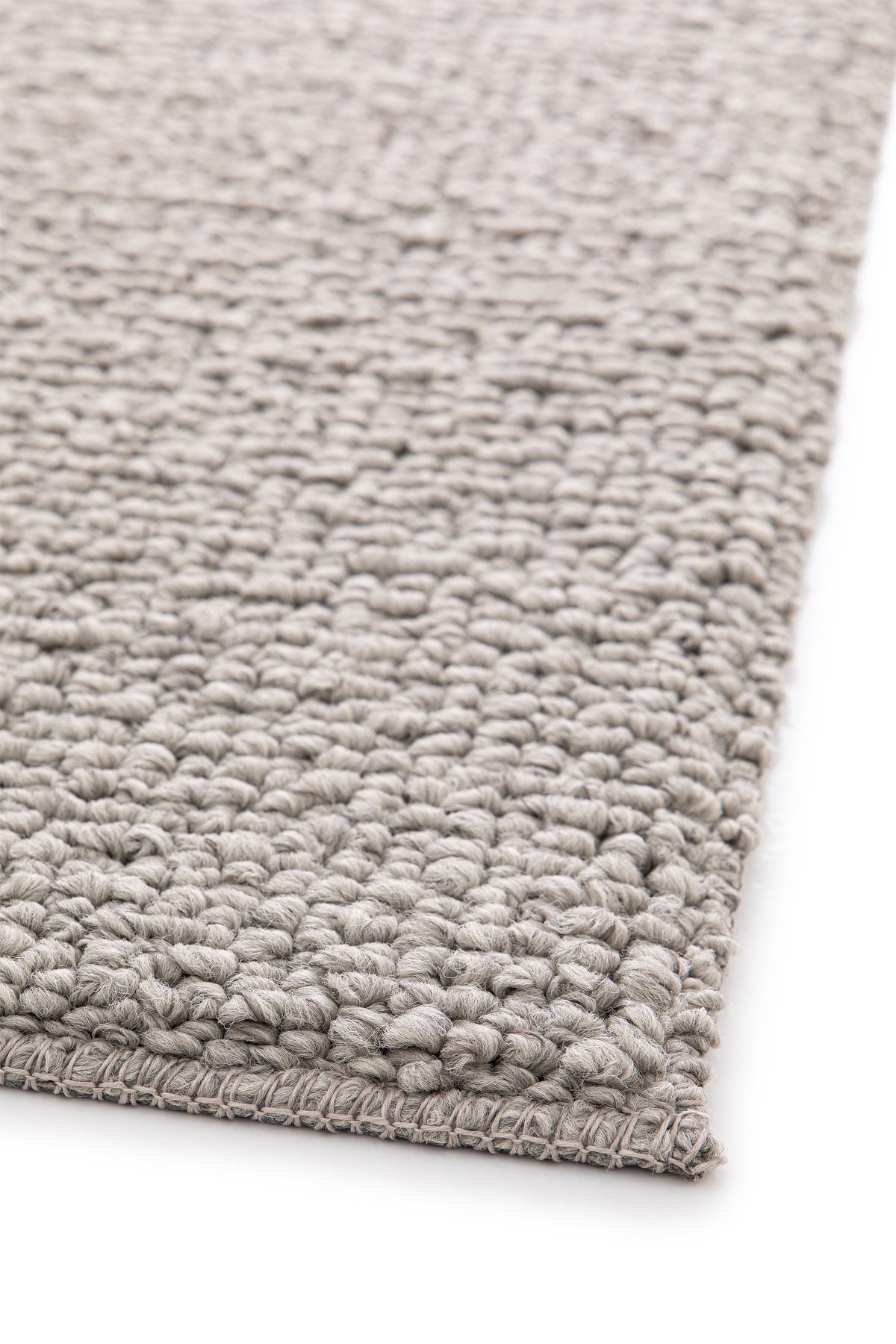Paradise Living – Tapete Bhutan 71591/060 Cinzento perspetiva do canto com textura bouclé volumosa e acabamento em cinzento natural