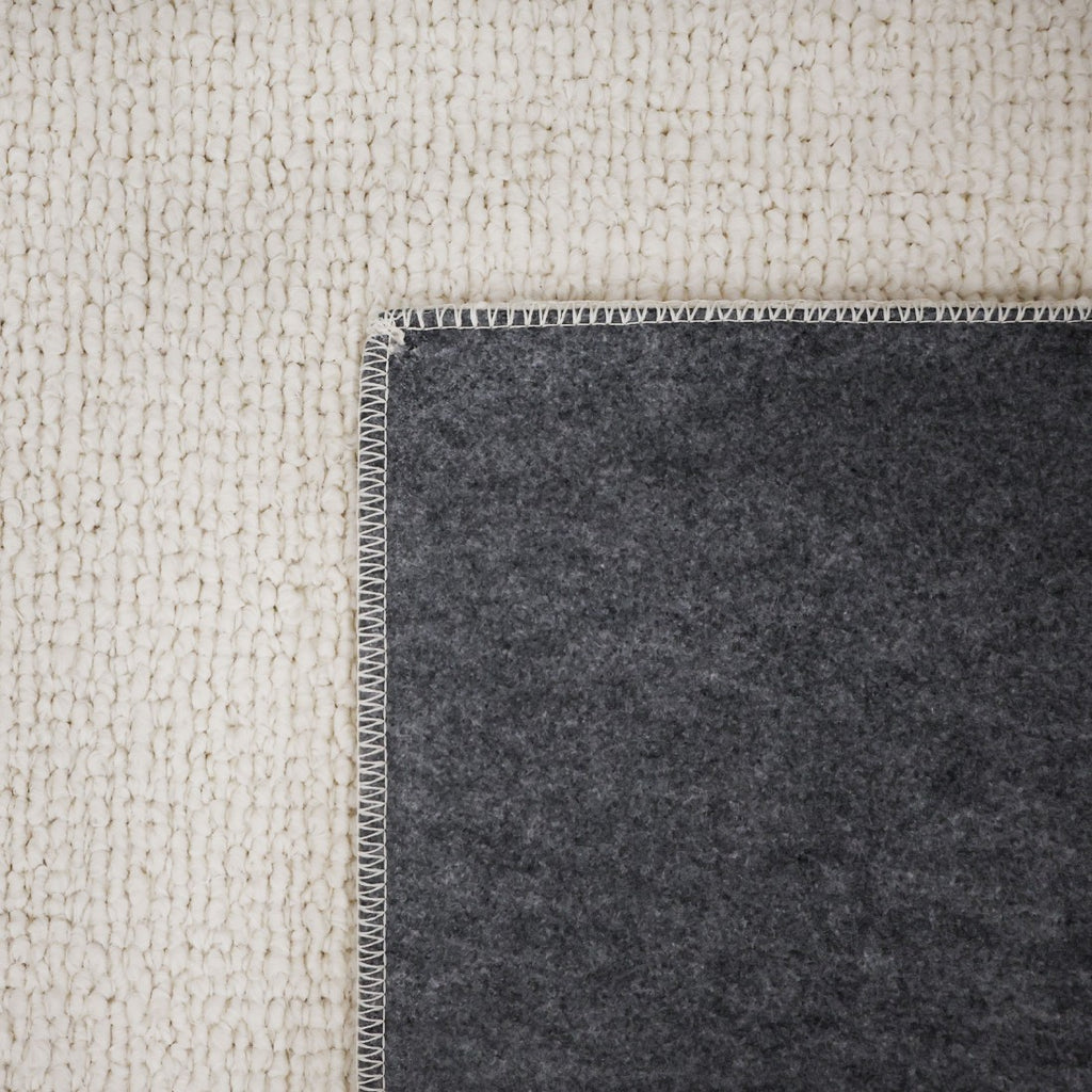Paradise Living – Tapete Bhutan 71591/066 Branco detalhe do canto dobrado mostrando frente em bouclé branco e verso em feltro cinzento escuro