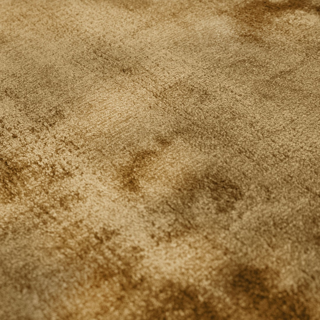 Paradise Living – Macro da superfície do Tapete Papua 115 Dourado em viscose, com textura sedosa e variações orgânicas de luz em tons dourado e âmbar